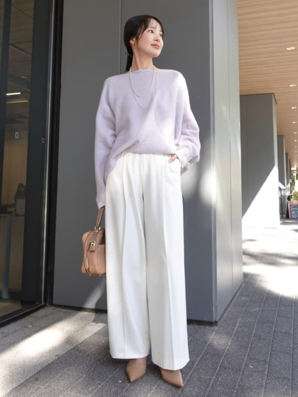 ブルー系のチェスターコート、ホワイト系のスラックス、ベージュ系のブーツを着用したレディースの冬コーディネートの3枚目の写真