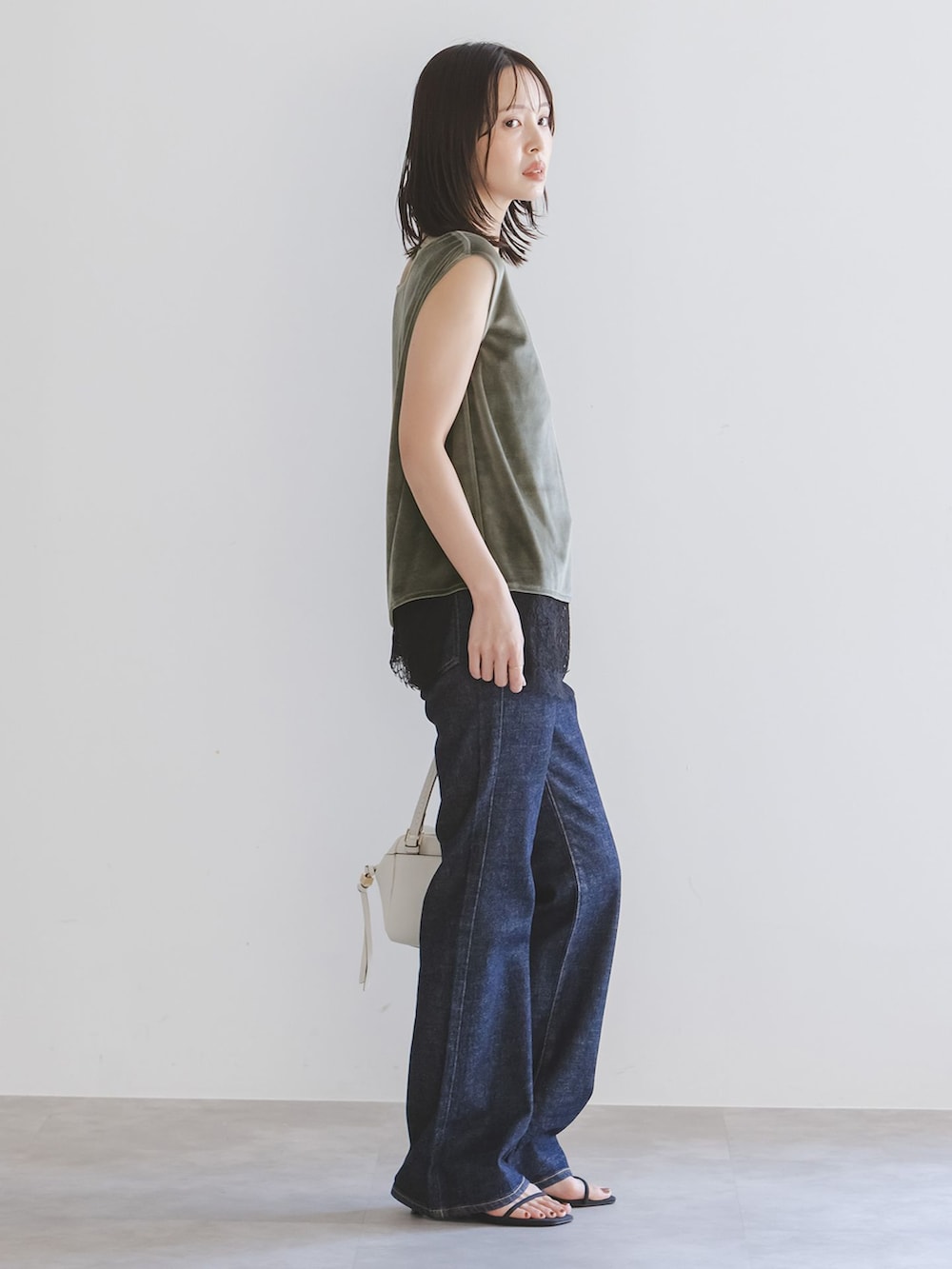ブルー系のデニムパンツ、ブラック系のキャミソール、グリーン系のTシャツ/カットソーを着用したレディースの夏コーディネートの2枚目の写真