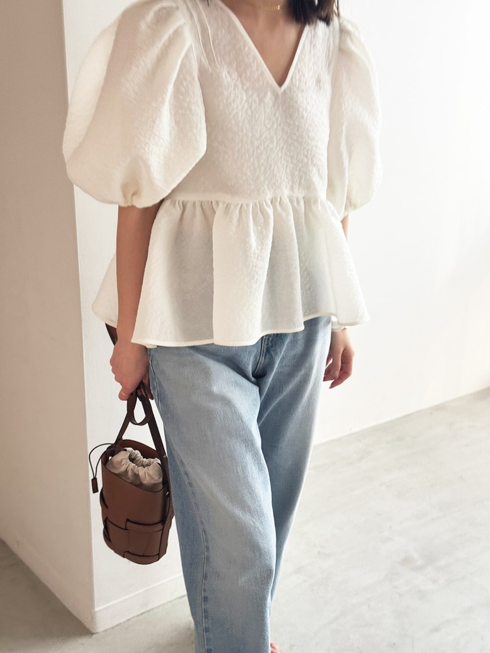 ホワイト系のシャツ/ブラウス、ブルー系のデニムパンツ、ベージュ系のサンダルを着用したレディースの春コーディネートの3枚目の写真