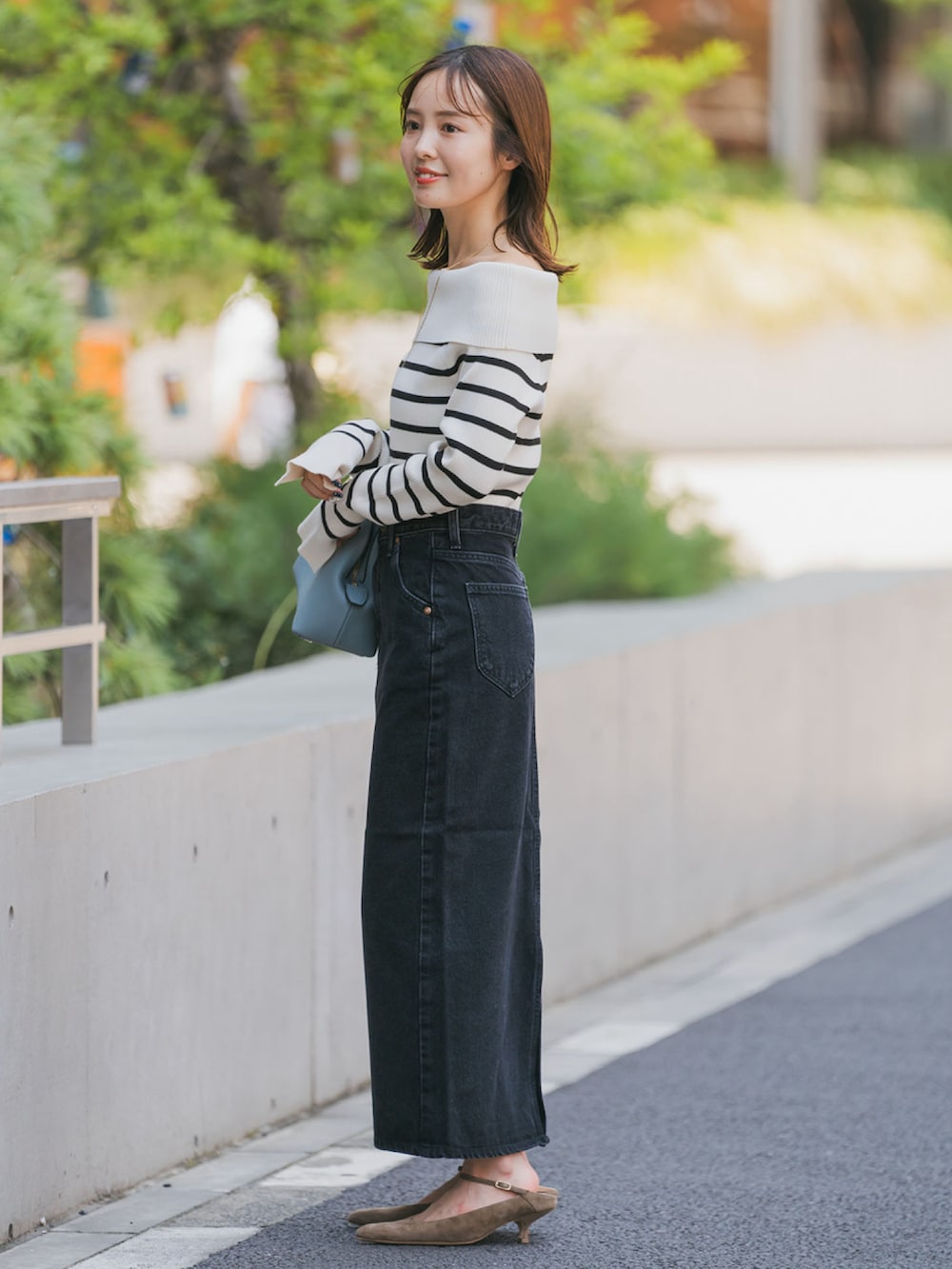 ブラック系のデニムスカート、その他のニット/セーター、ブルー系のショルダーバッグを着用したレディースの夏コーディネートの2枚目の写真