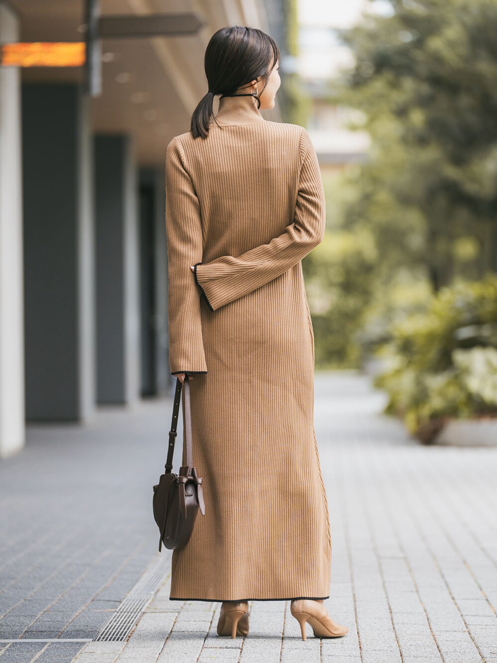 ベージュ系のワンピース、ベージュ系のブーツ、ブラウン系のショルダーバッグを着用したレディースの秋コーディネートの2枚目の写真