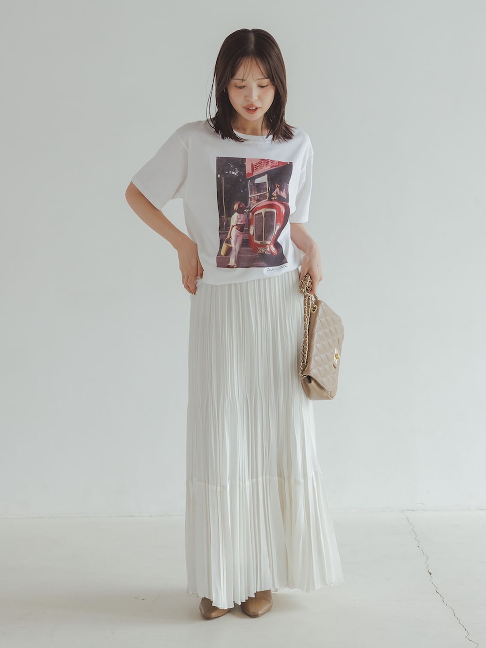 ブラック系のその他アウター、ホワイト系のスカート、ホワイト系のTシャツ/カットソーを着用したレディースの秋コーディネートの2枚目の写真