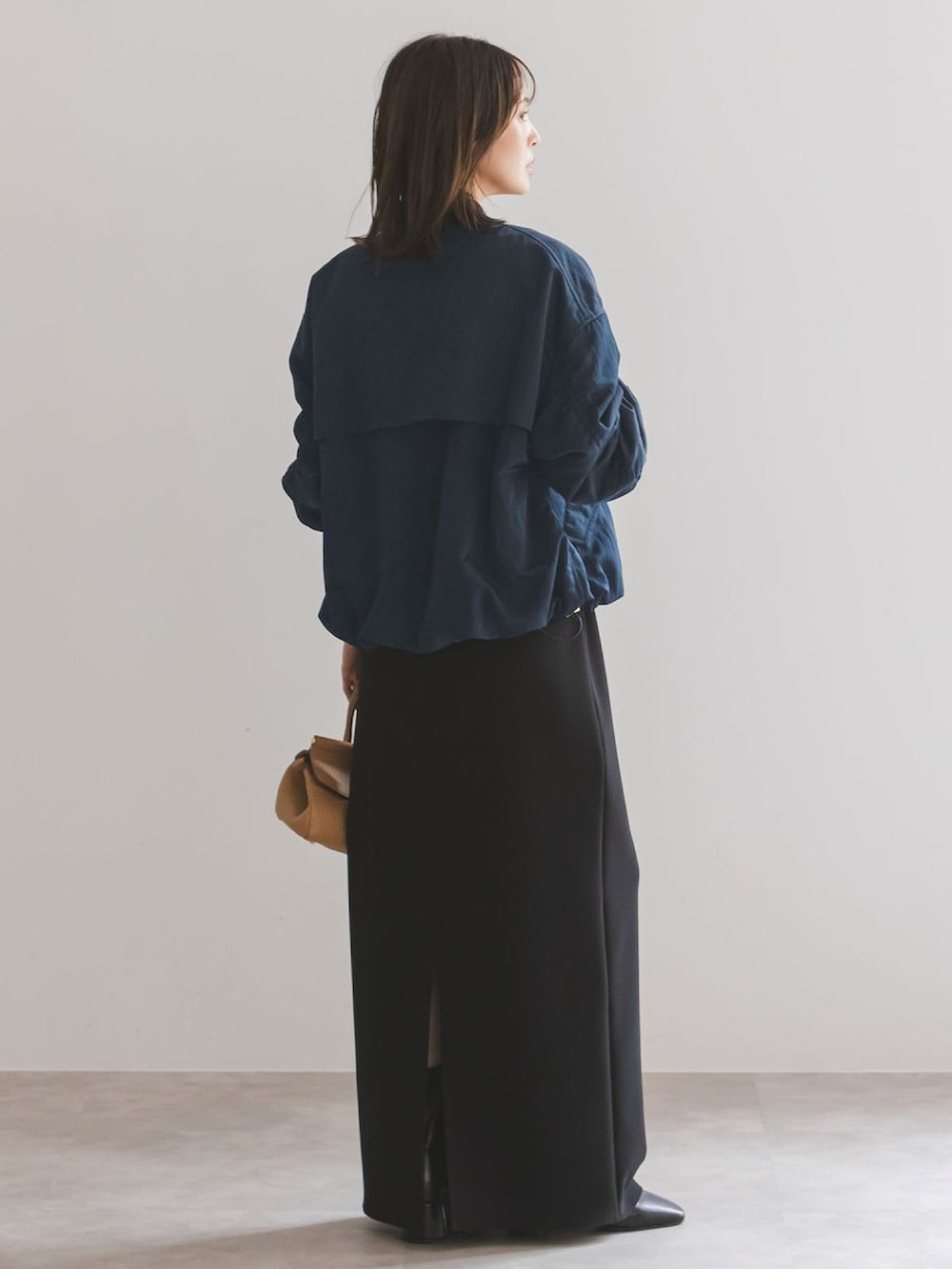 ブルー系のMA-1、グリーン系のワンピース、イエロー系のボストンバッグを着用したレディースの秋コーディネートの3枚目の写真