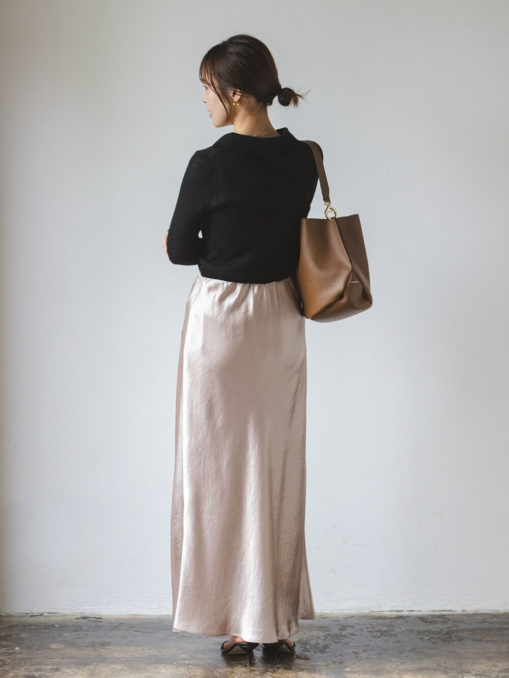 ブラック系のニット/セーター、ベージュ系のスカート、ブラック系のサンダルを着用したレディースの夏コーディネートの2枚目の写真