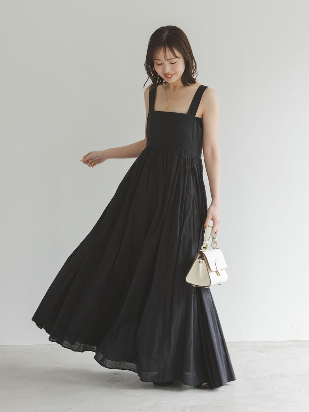 ブラック系のワンピース、グレー系のテーラードジャケット、ブラック系のサンダルを着用したレディースの春コーディネートの2枚目の写真