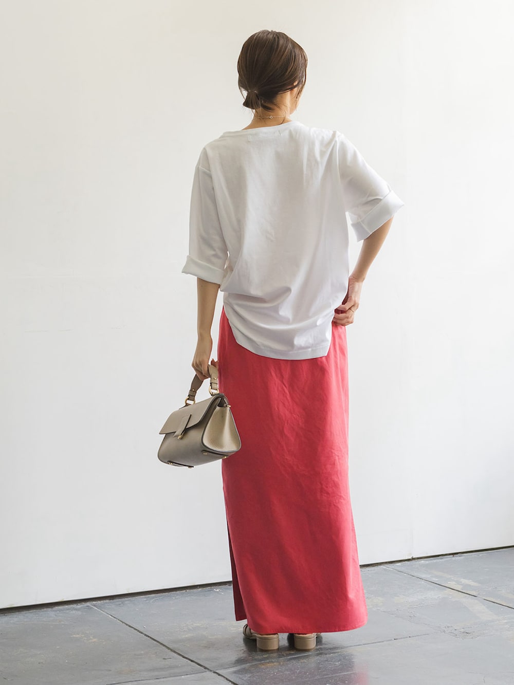 レッド系のスカート、ベージュ系のショルダーバッグ、ホワイト系のTシャツ/カットソーを着用したレディースの夏コーディネートの3枚目の写真