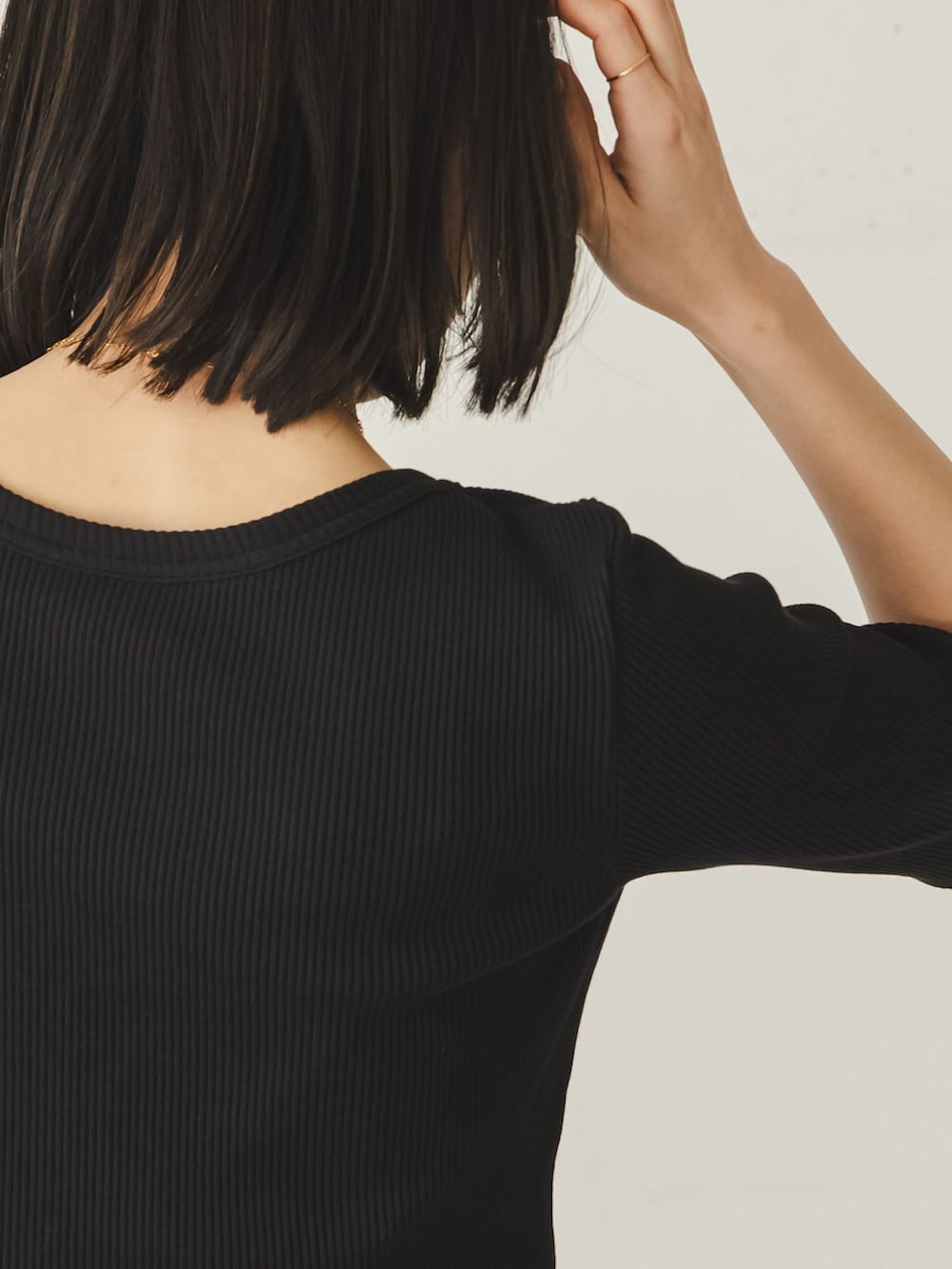 ベージュ系のスラックス、ブラック系のTシャツ/カットソー、ブラック系のボストンバッグを着用したレディースの冬コーディネートの6枚目の写真