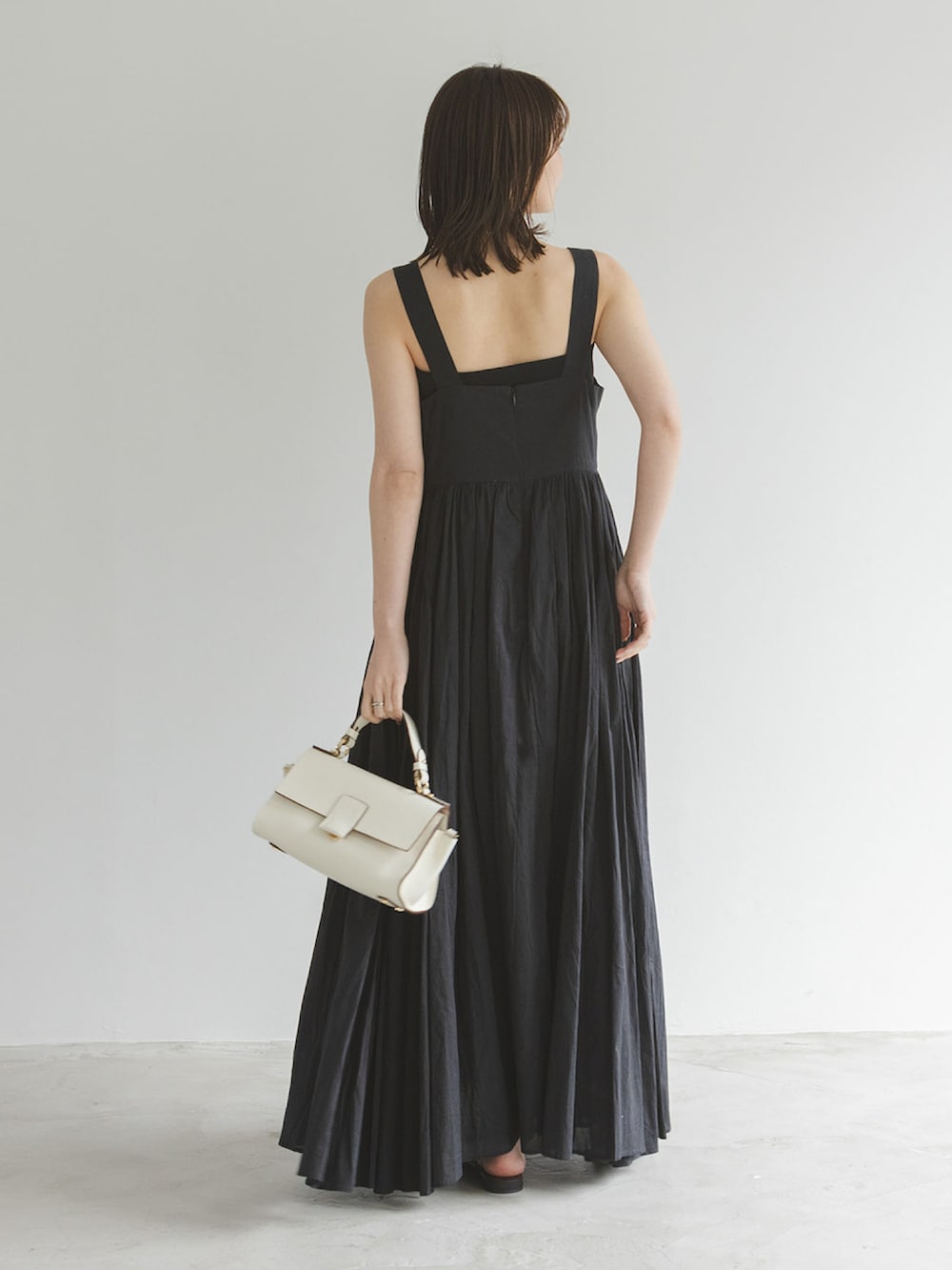 ブラック系のワンピース、グレー系のテーラードジャケット、ブラック系のサンダルを着用したレディースの春コーディネートの3枚目の写真