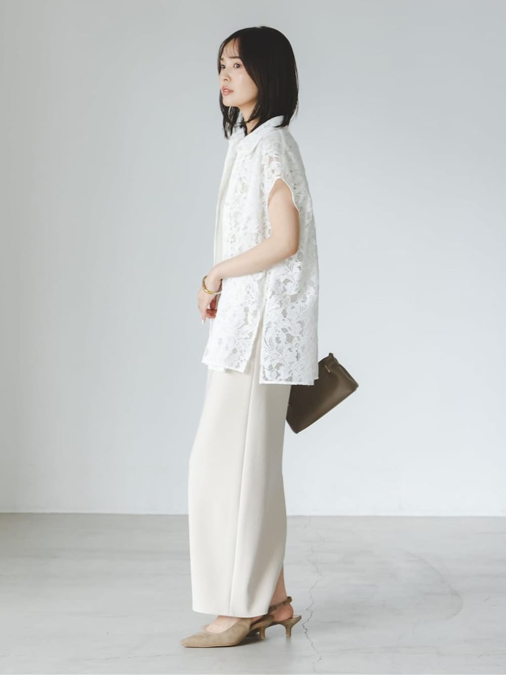 ベージュ系のワンピース、ホワイト系のシャツ/ブラウス、ベージュ系のパンプスを着用したレディースの夏コーディネートの2枚目の写真