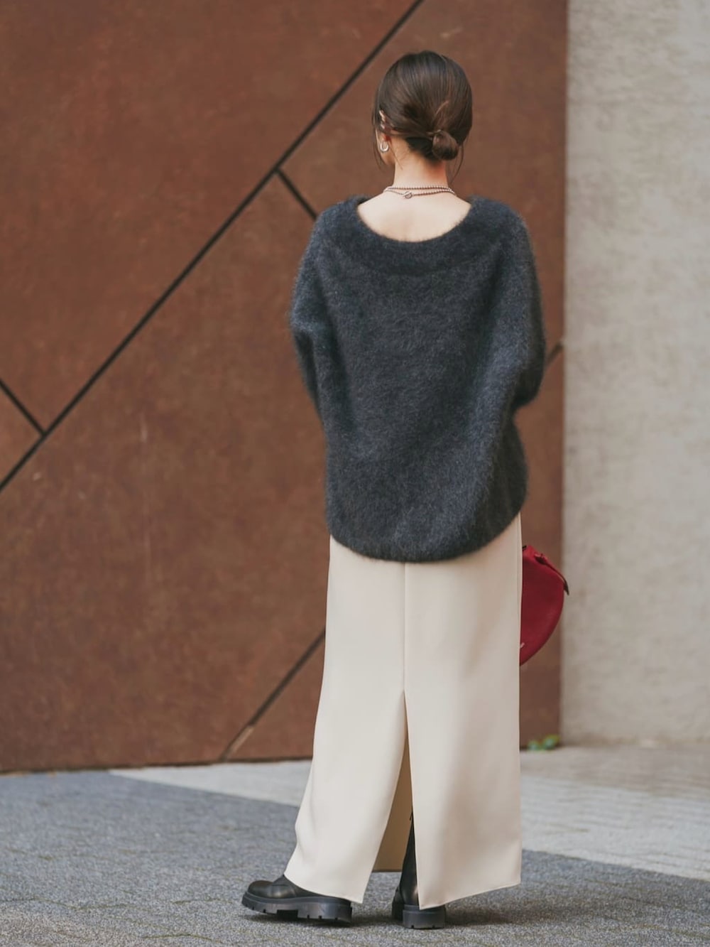 ブラウン系のニット/セーター、ブラック系のブーツ、グレー系のワンピースを着用したレディースの冬コーディネートの2枚目の写真