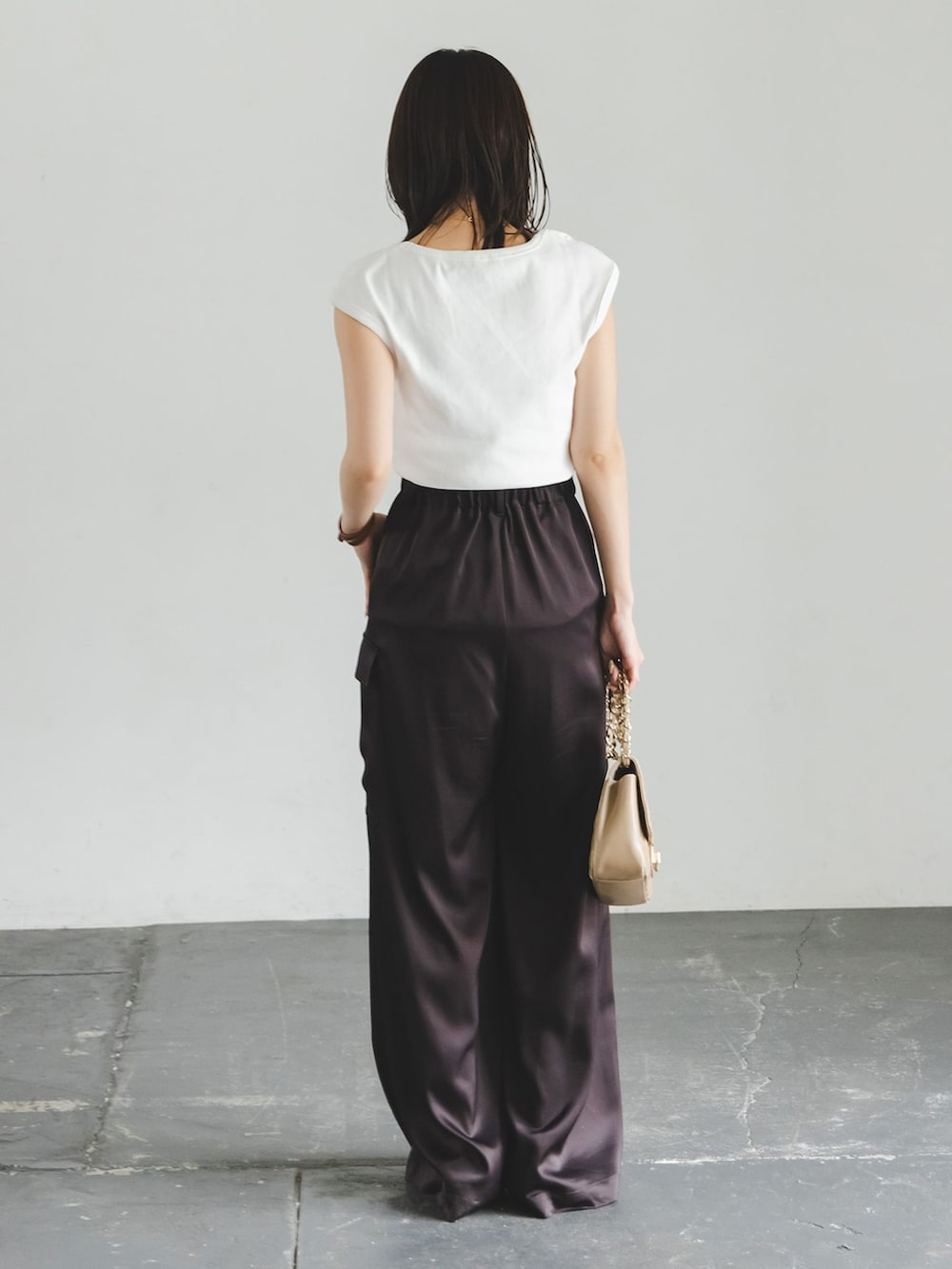 ブラウン系のカーゴパンツ、ホワイト系のTシャツ/カットソー、ベージュ系のショルダーバッグを着用したレディースの夏コーディネートの2枚目の写真