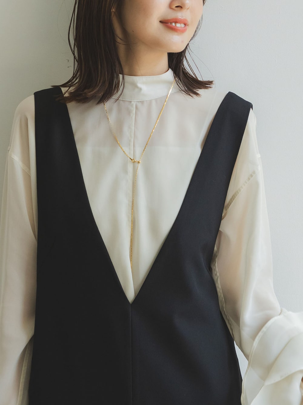 ホワイト系のシャツ/ブラウス、ブラック系のワンピース、ブラック系のショルダーバッグを着用したレディースの秋コーディネートの2枚目の写真