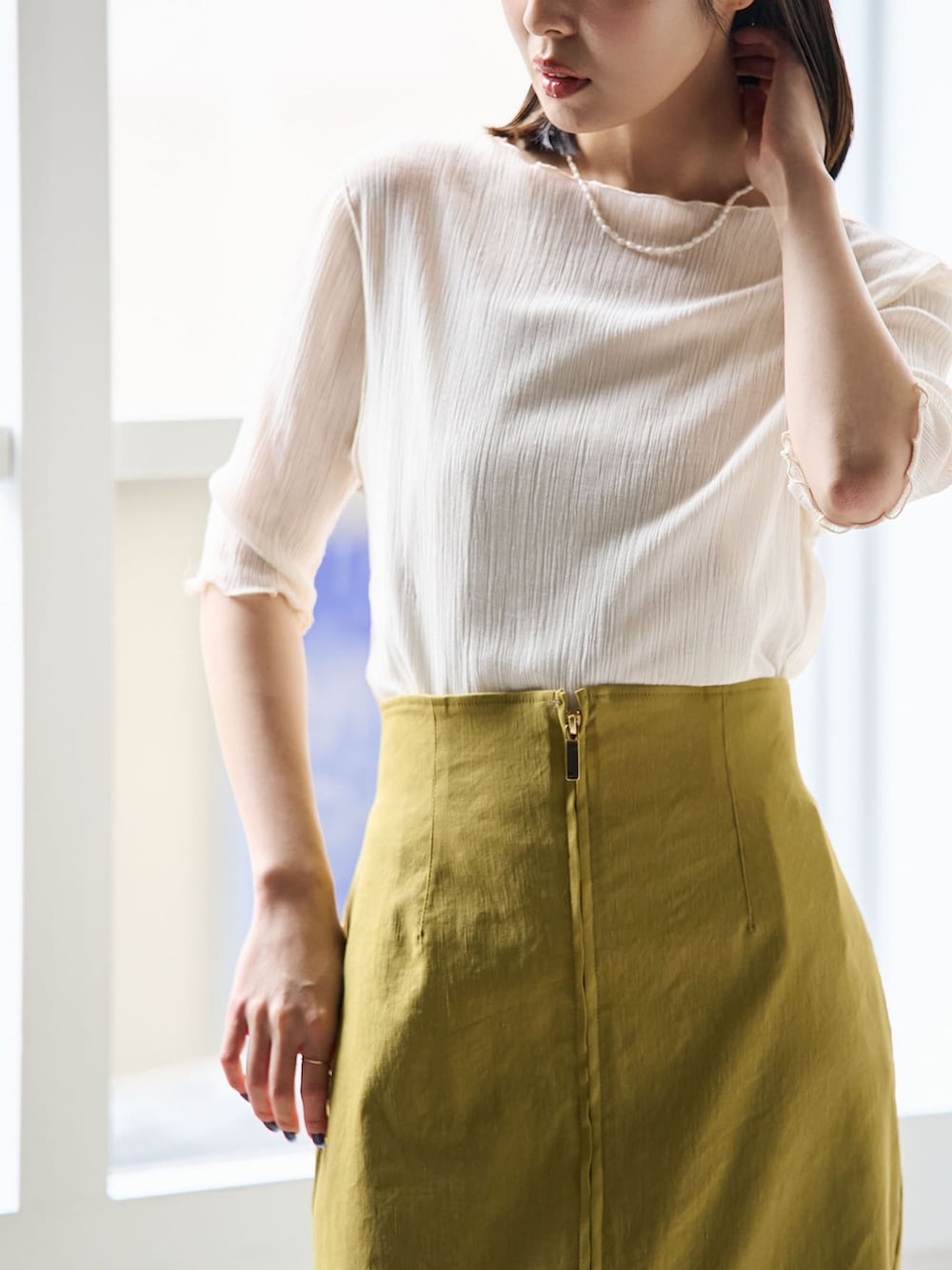 イエロー系のスカート、ホワイト系のTシャツ/カットソー、ブラウン系のショルダーバッグを着用したレディースの春コーディネートの4枚目の写真