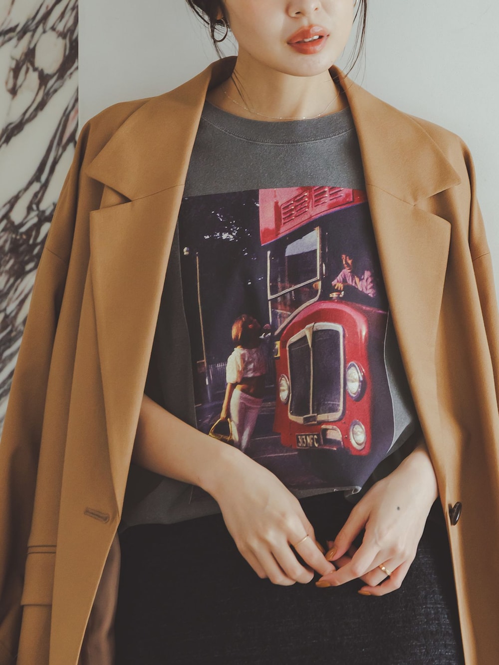 イエロー系のテーラードジャケット、ブラック系のスカート、グレー系のTシャツ/カットソーを着用したレディースの秋コーディネートの8枚目の写真