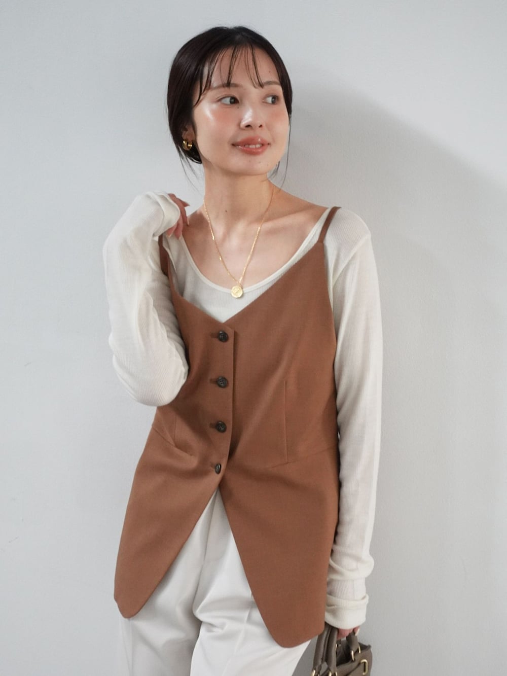 ホワイト系のスラックス、イエロー系のシャツ/ブラウス、ホワイト系のTシャツ/カットソーを着用したレディースの夏コーディネートの5枚目の写真