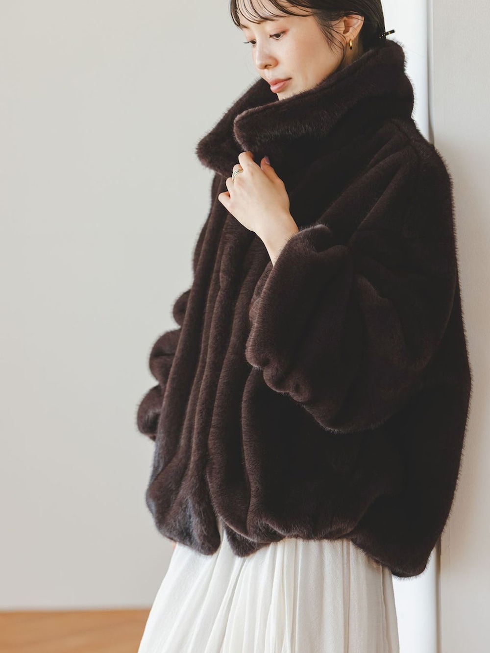 ブラウン系のその他アウター、ホワイト系のスカート、ベージュ系のショルダーバッグを着用したレディースの冬コーディネートの4枚目の写真