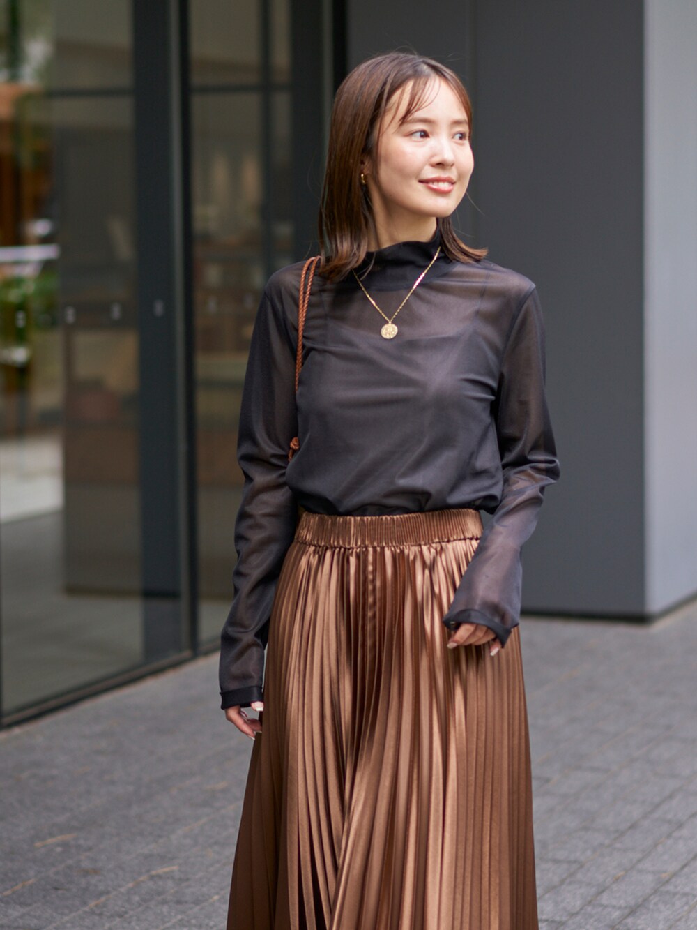 ブラック系のTシャツ/カットソー、ブラウン系のスカートを着用したレディースの秋コーディネートの2枚目の写真