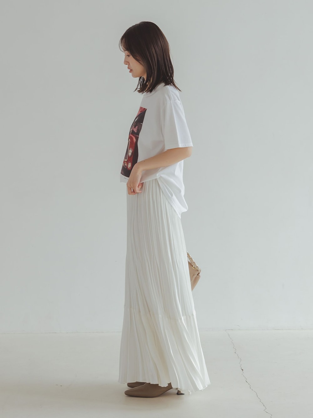 ブラック系のその他アウター、ホワイト系のスカート、ホワイト系のTシャツ/カットソーを着用したレディースの秋コーディネートの4枚目の写真