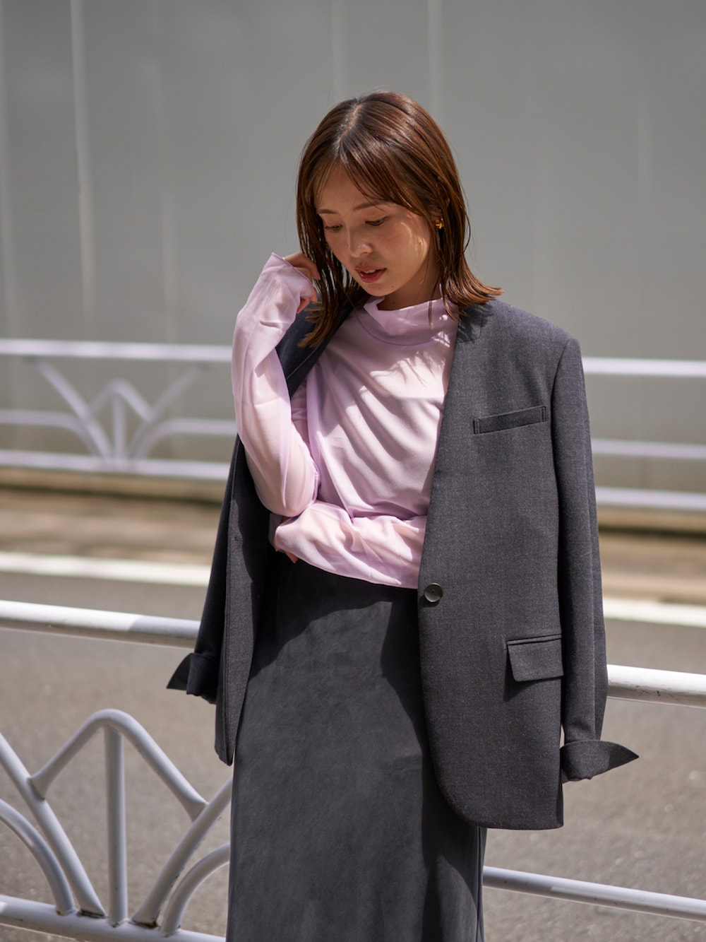 パープル系のTシャツ/カットソー、グレー系のノーカラージャケット、ブルー系のスカートを着用したレディースの秋コーディネートの2枚目の写真