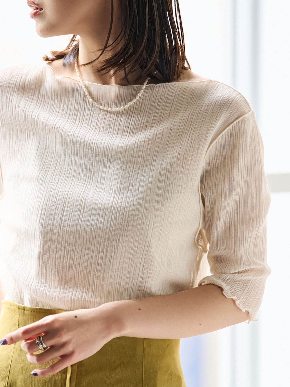 イエロー系のスカート、ホワイト系のTシャツ/カットソー、ブラウン系のショルダーバッグを着用したレディースの春コーディネートの5枚目の写真