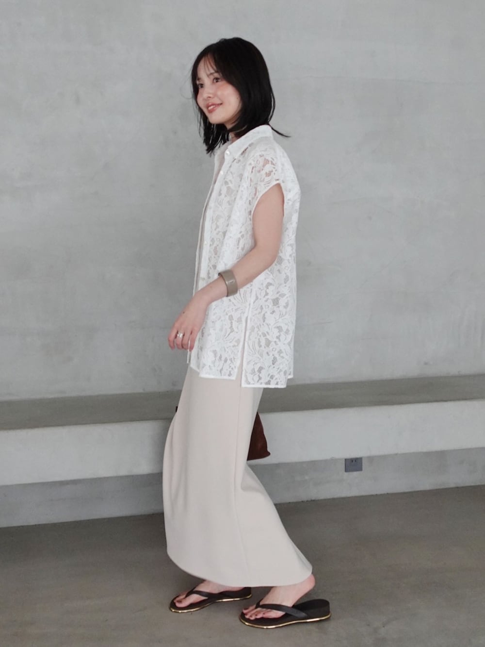 ベージュ系のワンピース、ホワイト系のシャツ/ブラウス、ブラウン系のサンダルを着用したレディースの夏コーディネートの3枚目の写真