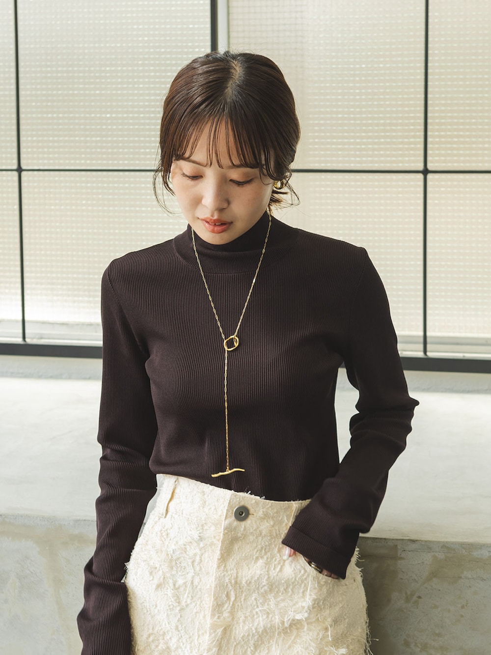 ブラウン系のニット/セーター、ベージュ系のスカート、イエロー系のショルダーバッグを着用したレディースの秋コーディネートの4枚目の写真