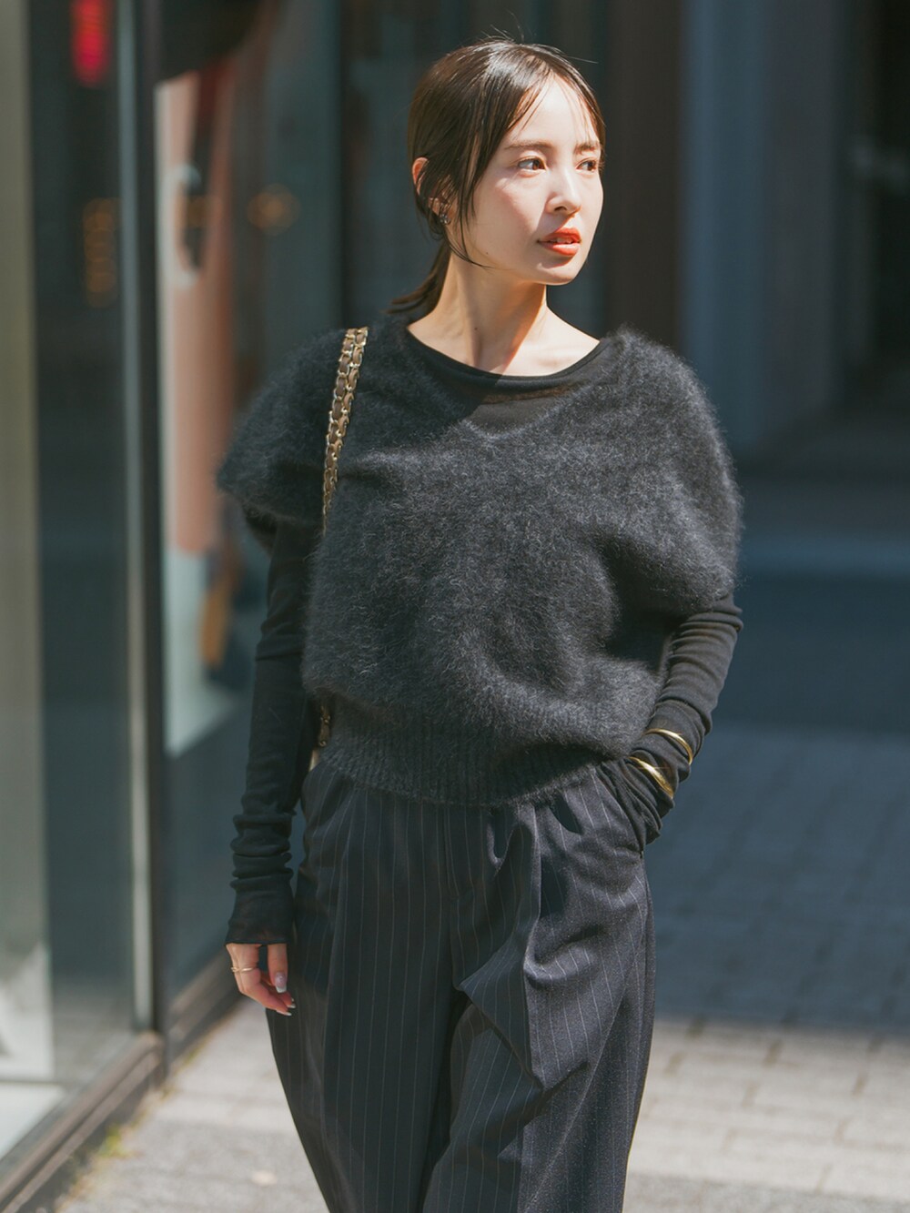 グレー系のベスト、ブラック系のTシャツ/カットソー、ベージュ系のショルダーバッグを着用したレディースの秋コーディネートの3枚目の写真