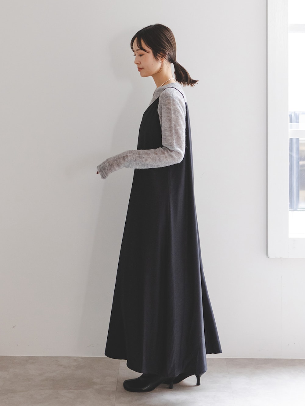 ブラック系のワンピース、ブラック系のブーツ、ブラック系のショルダーバッグを着用したレディースの冬コーディネートの2枚目の写真