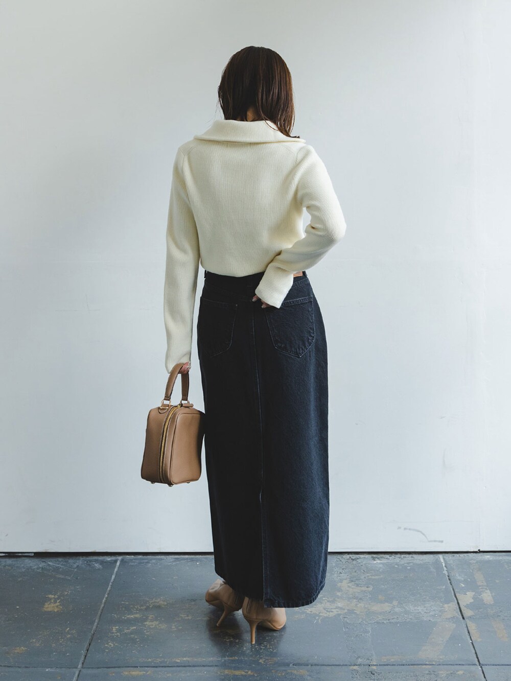 ホワイト系のニット/セーター、ブラック系のデニムスカート、イエロー系のショルダーバッグを着用したレディースの秋コーディネートの2枚目の写真