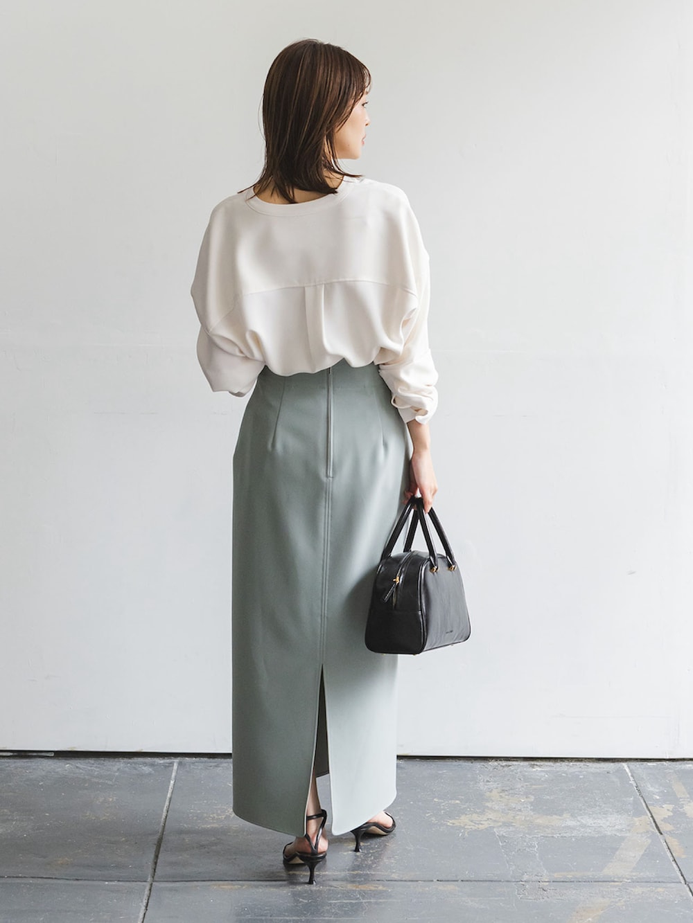 ホワイト系のシャツ/ブラウス、グリーン系のスカート、ブラック系のサンダルを着用したレディースの秋コーディネートの3枚目の写真