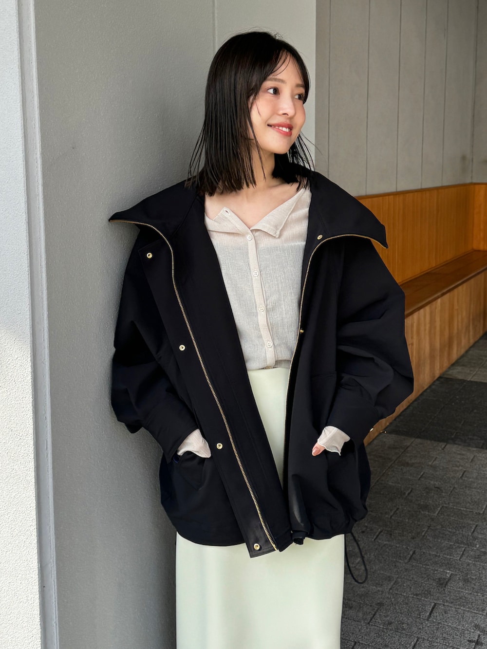 ブラック系のその他アウター、ベージュ系のTシャツ/カットソー、イエロー系のスカートを着用したレディースの冬コーディネートの2枚目の写真