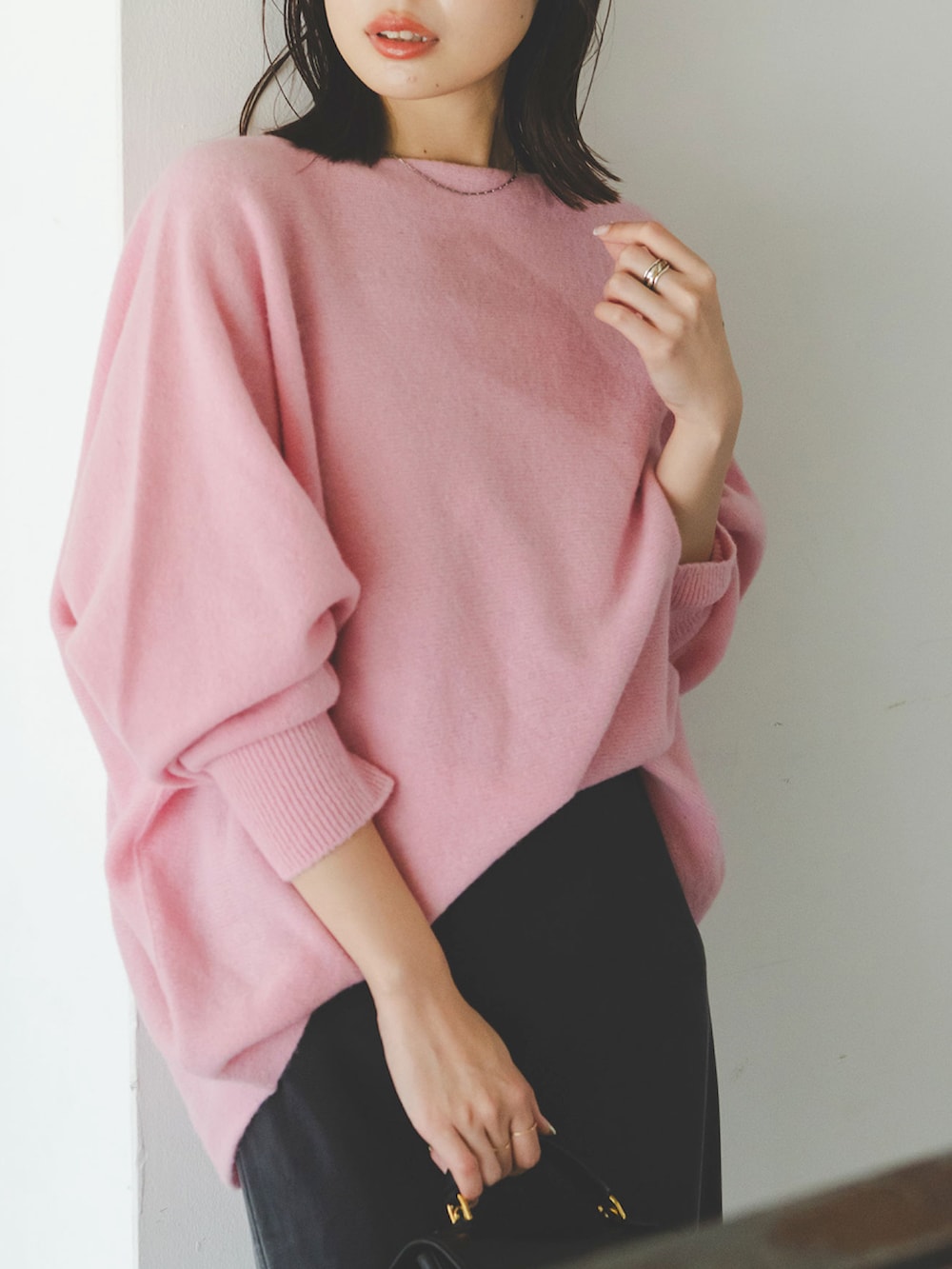 ピンク系のニット/セーター、ブルー系のスカートを着用したレディースの秋コーディネートの3枚目の写真