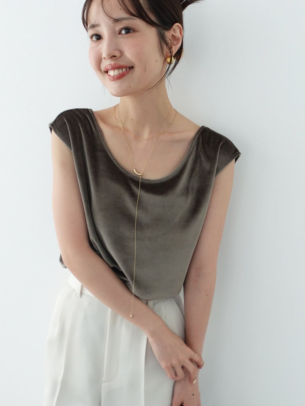 ホワイト系のスラックス、グリーン系のTシャツ/カットソー、ブラウン系のハンドバッグを着用したレディースの夏コーディネートの7枚目の写真