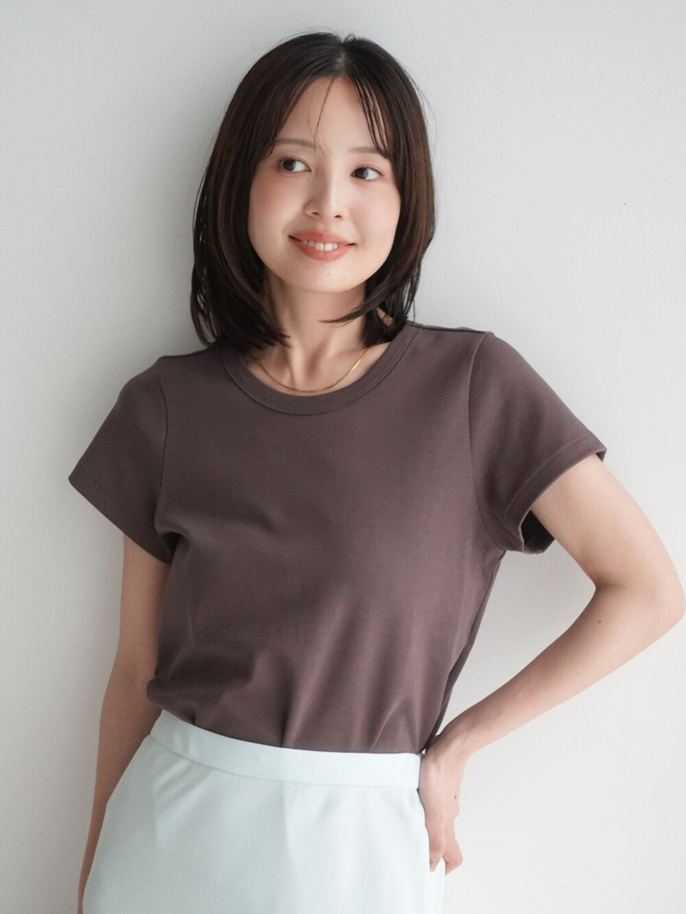 グリーン系のスカート、ブラウン系のTシャツ/カットソー、ブラウン系のサンダルを着用したレディースの夏コーディネートの6枚目の写真