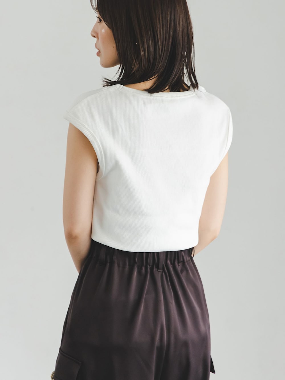 ブラウン系のカーゴパンツ、ホワイト系のTシャツ/カットソー、ベージュ系のショルダーバッグを着用したレディースの夏コーディネートの6枚目の写真