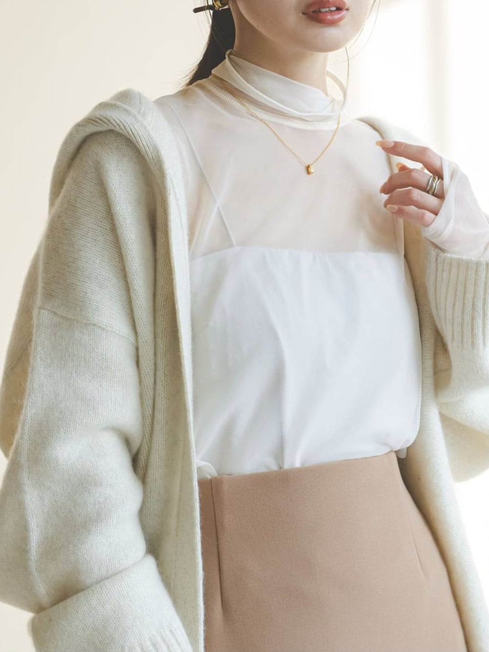 ホワイト系のカーディガン/ボレロ、イエロー系のスカート、ホワイト系のTシャツ/カットソーを着用したレディースの冬コーディネートの3枚目の写真