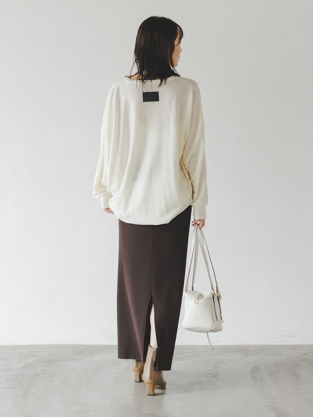ブラウン系のスカート、ホワイト系のTシャツ/カットソー、ホワイト系のショルダーバッグを着用したレディースの秋コーディネートの3枚目の写真