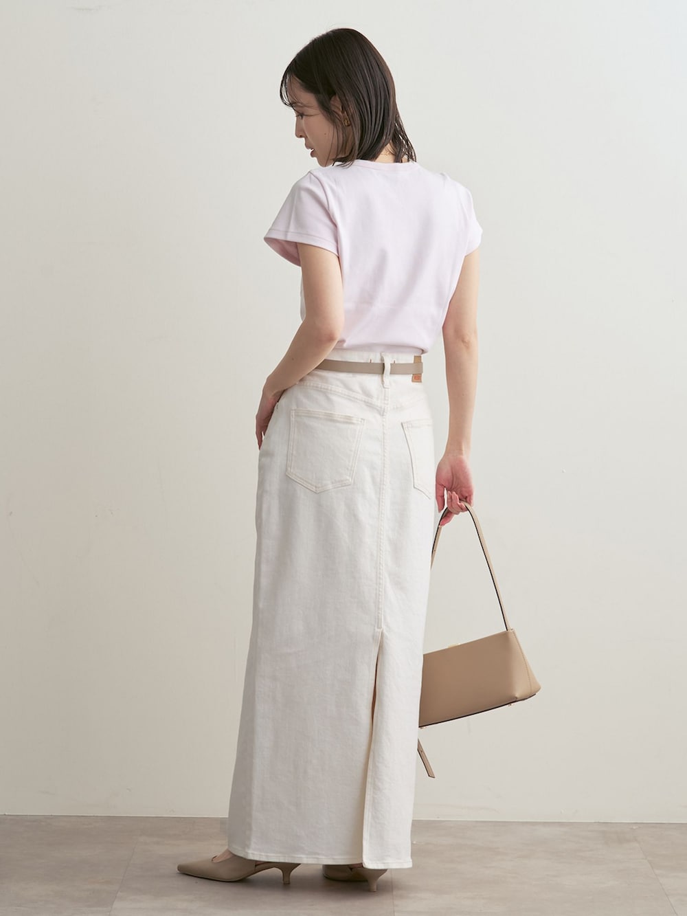 ホワイト系のデニムスカート、ピンク系のTシャツ/カットソー、ベージュ系のパンプスを着用したレディースの春コーディネートの3枚目の写真