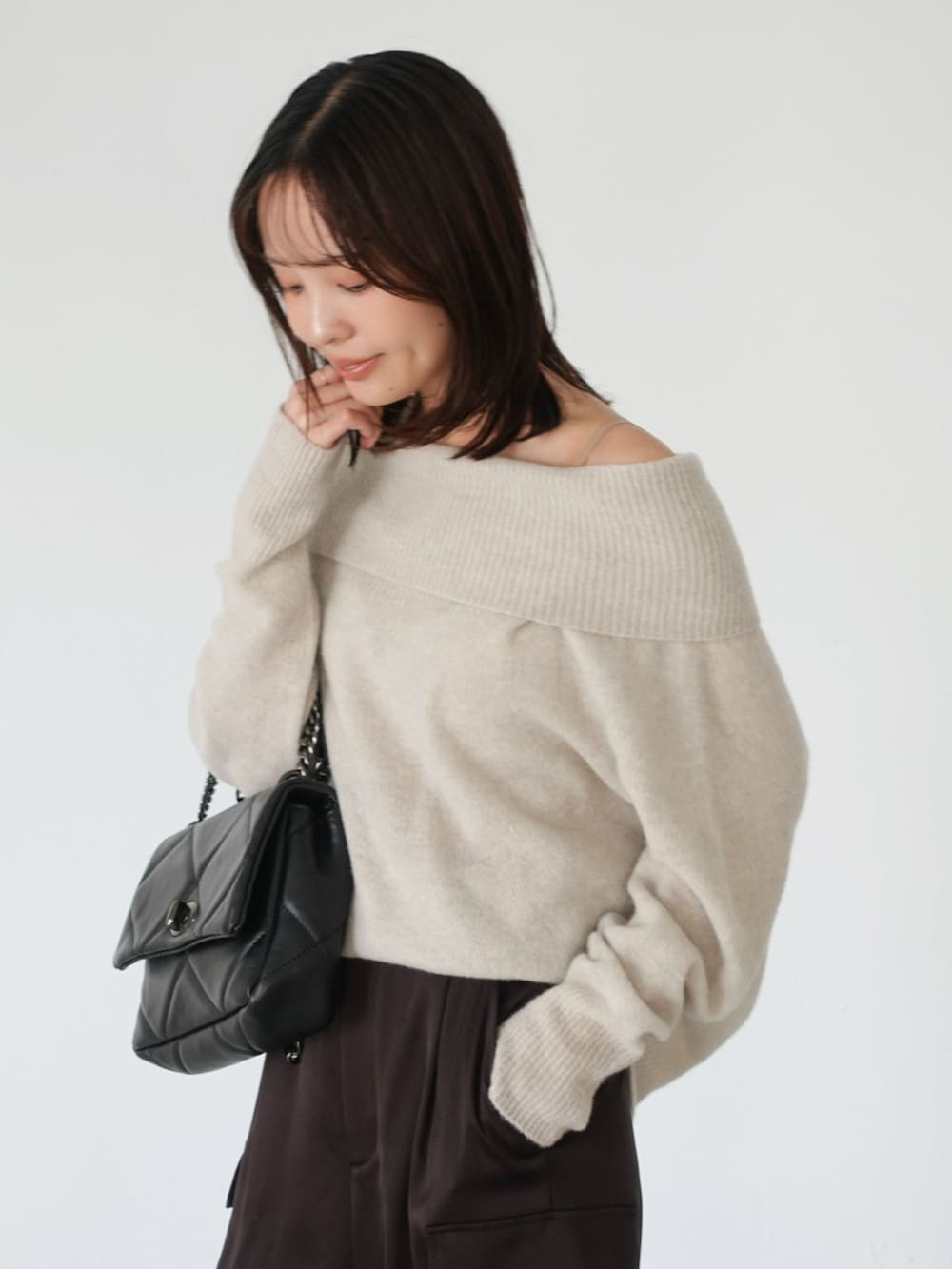 ブラウン系のカーゴパンツ、ベージュ系のニット/セーター、ブラック系のショルダーバッグを着用したレディースの夏コーディネートの7枚目の写真