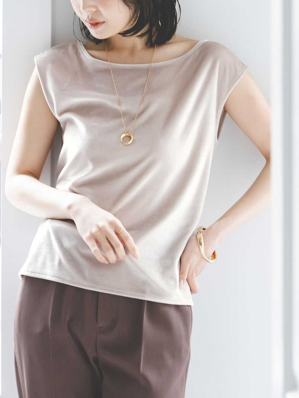 ブラウン系のスラックス、ベージュ系のTシャツ/カットソー、ホワイト系のボストンバッグを着用したレディースの夏コーディネートの6枚目の写真