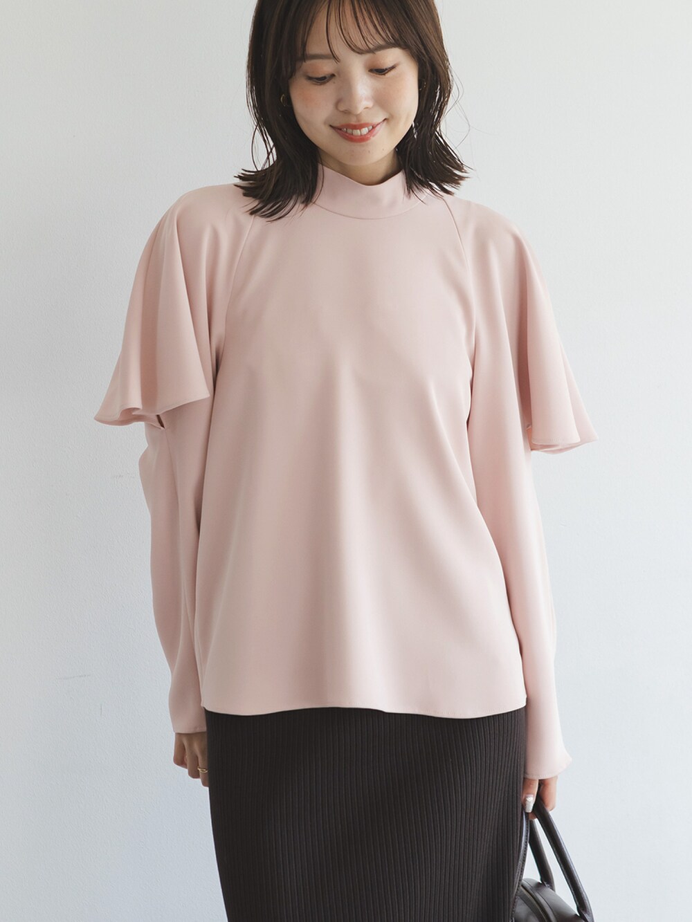 ピンク系のシャツ/ブラウス、ブラウン系のスカート、ブラウン系のハンドバッグを着用したレディースの秋コーディネートの2枚目の写真