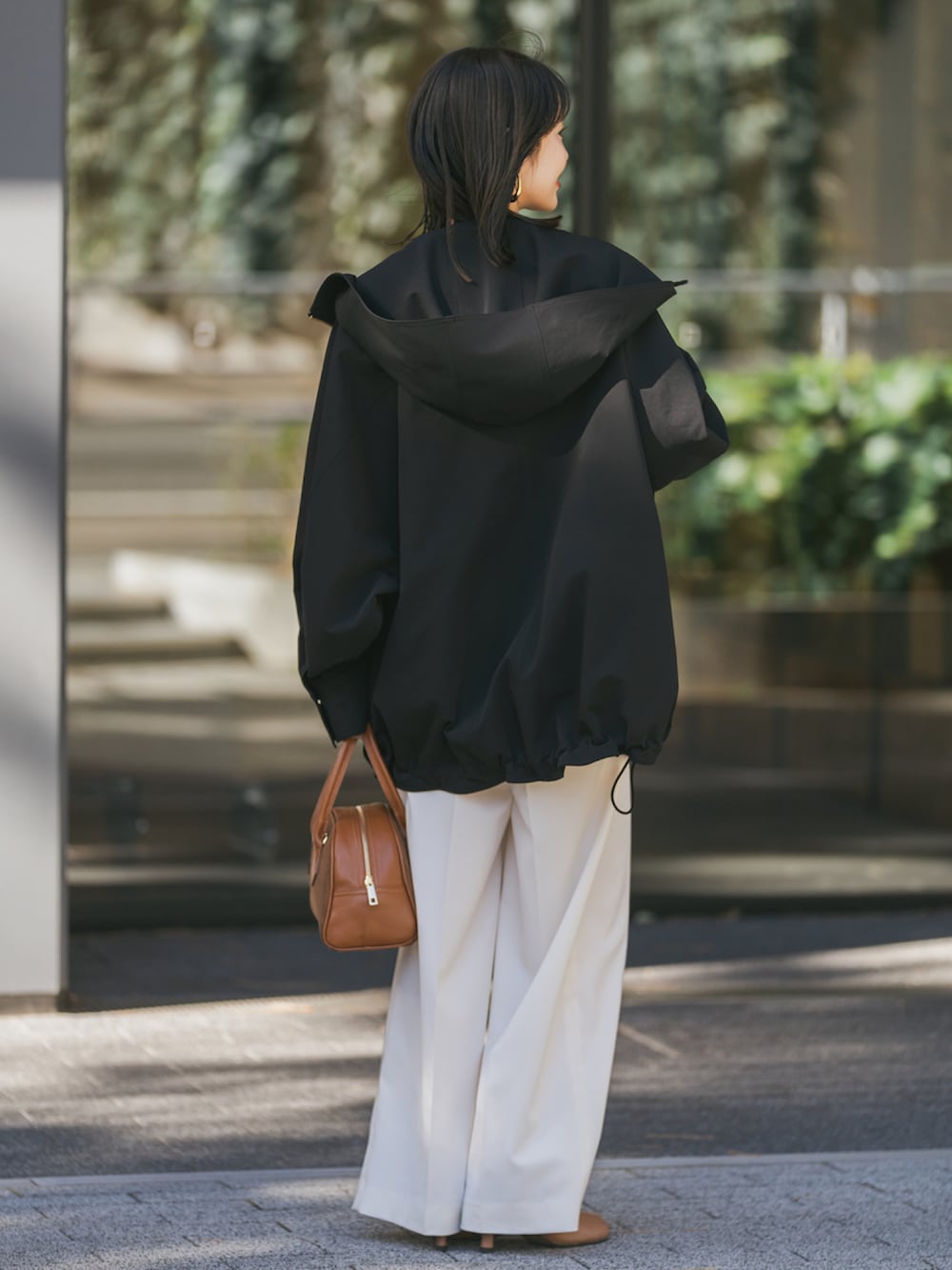 ブラック系のその他アウター、イエロー系のニット/セーター、ベージュ系のスラックスを着用したレディースの冬コーディネートの3枚目の写真