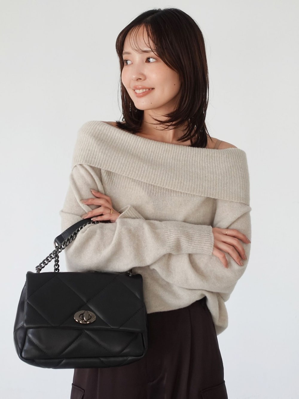 ブラウン系のカーゴパンツ、ベージュ系のニット/セーター、ブラック系のショルダーバッグを着用したレディースの夏コーディネートの6枚目の写真