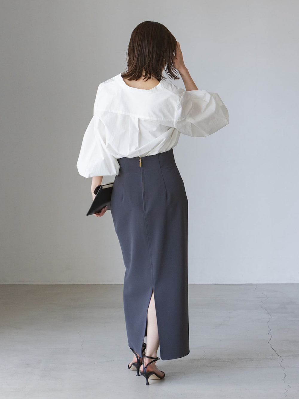 ホワイト系のシャツ/ブラウス、ブラック系のサンダル、ホワイト系のクラッチバッグを着用したレディースの夏コーディネートの3枚目の写真