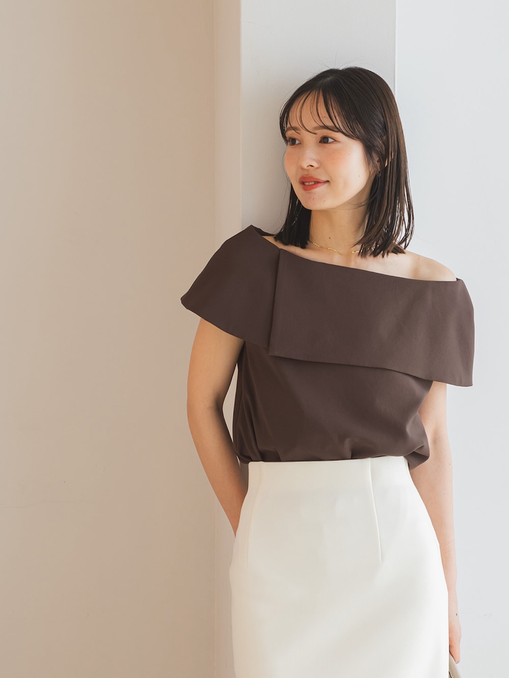 ブラウン系のシャツ/ブラウス、ホワイト系のスカート、ベージュ系のショルダーバッグを着用したレディースの春コーディネートの3枚目の写真