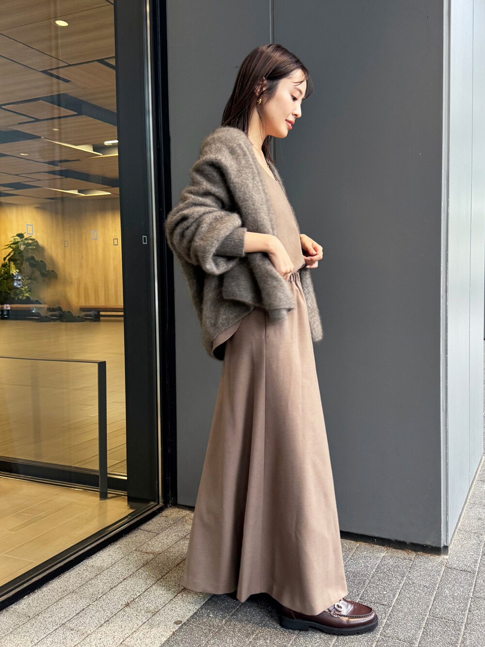 ブラウン系のワンピース、ブラウン系のローファー、ブラウン系のカーディガン/ボレロを着用したレディースの秋コーディネートの2枚目の写真