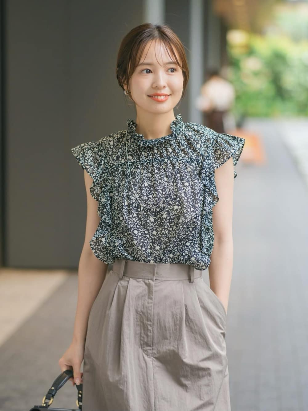 ブラック系のシャツ/ブラウス、グレー系のスカートを着用したレディースの夏コーディネートの2枚目の写真