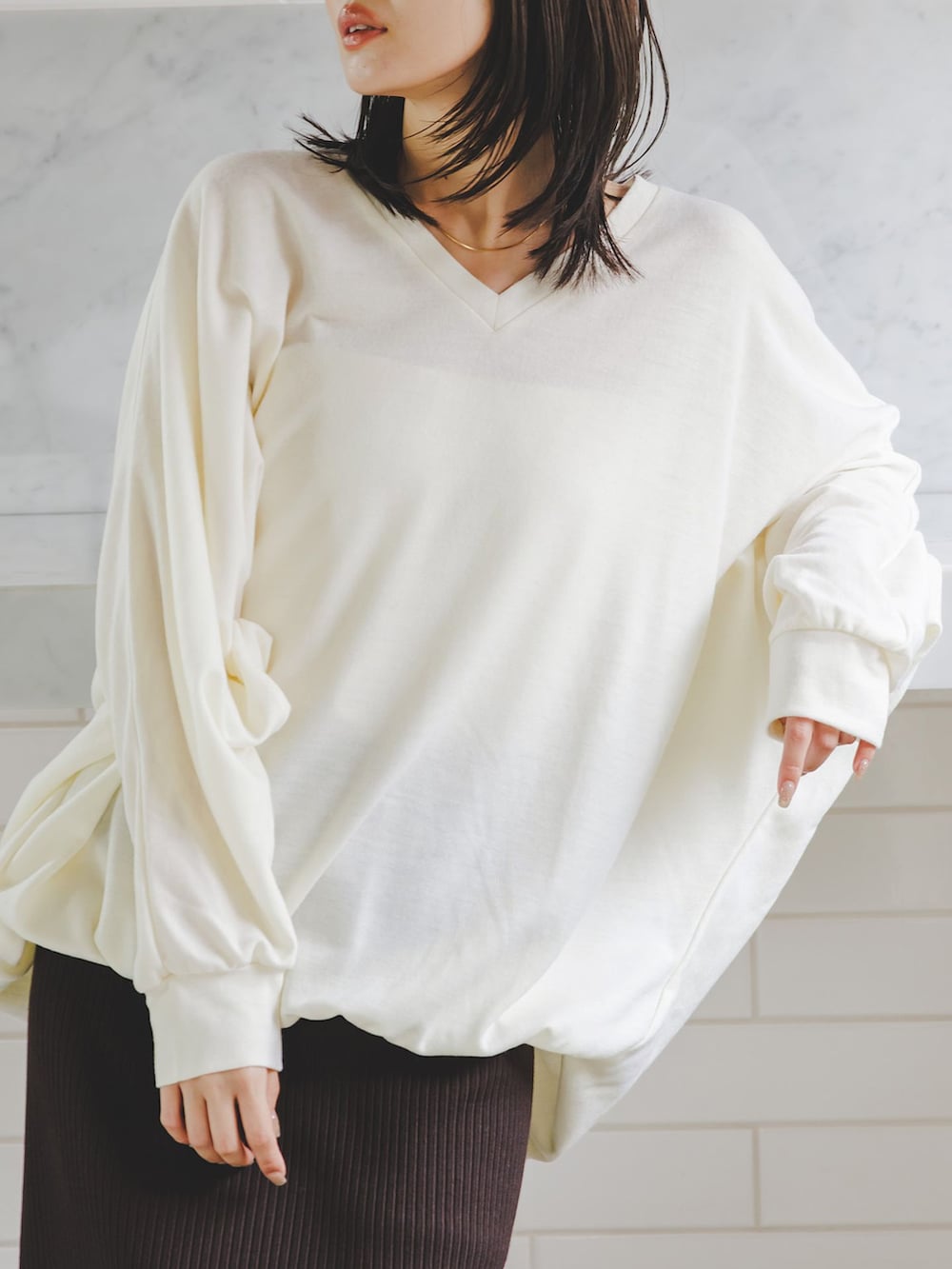 ブラウン系のスカート、ホワイト系のTシャツ/カットソー、ホワイト系のショルダーバッグを着用したレディースの秋コーディネートの8枚目の写真