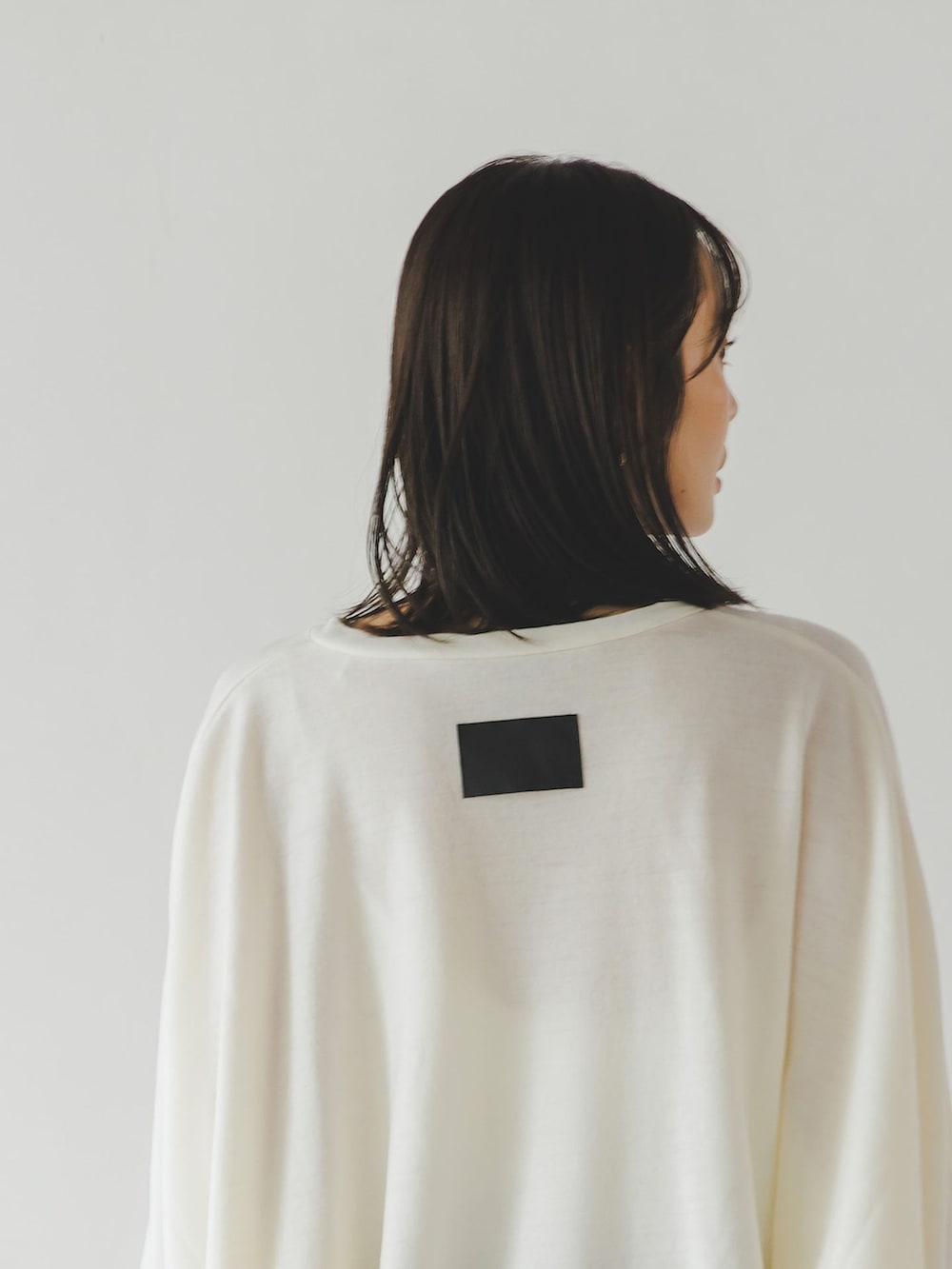 ブラウン系のスカート、ホワイト系のTシャツ/カットソー、ホワイト系のショルダーバッグを着用したレディースの秋コーディネートの6枚目の写真