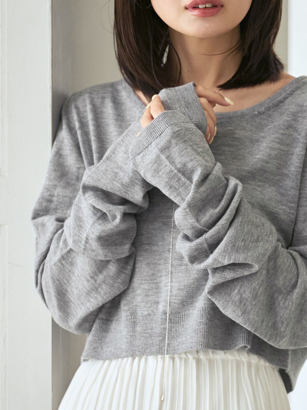 ホワイト系のスカート、グレー系のニット/セーター、グリーン系のブーツを着用したレディースの夏コーディネートの6枚目の写真